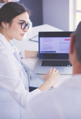 Serious medical team using a laptop in a bright office