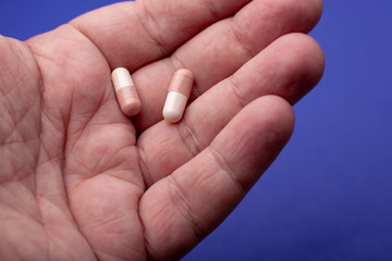 Close-up shot of a hand holding two pills