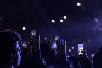 many people who dance and record with the phones at the live music concert