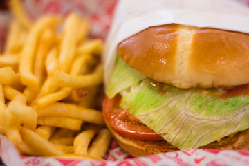 Delicious burger and fries served in a tray with decorated paper