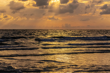 Sunset beach in Florida on the Gulf of Mexico with a bright sky with light shining through the clouds