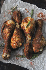 Appetizing chicken legs in breading on paper. Top view.