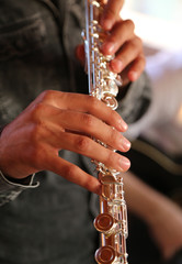 Professional elegant man flutist performing in a white room, hands close up