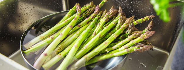 Waschen von frischem Spargel in Spülbecken