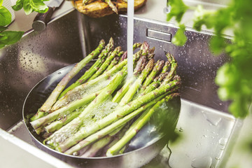 Waschen von frischem Spargel in Spülbecken
