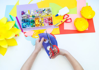 A child makes a bird mask out of paper. Master class crafts. Tropical Parrot.