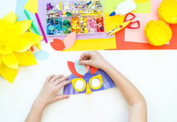 A child makes a bird mask out of paper. Master class crafts. Tropical Parrot.