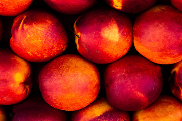 Fototapeta na wymiar Close view of several ripe peaches of vibrant colors. Symmetric pattern formed by tropical fruits.