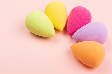 Colorful beauty sponges on pink background. Copy space.