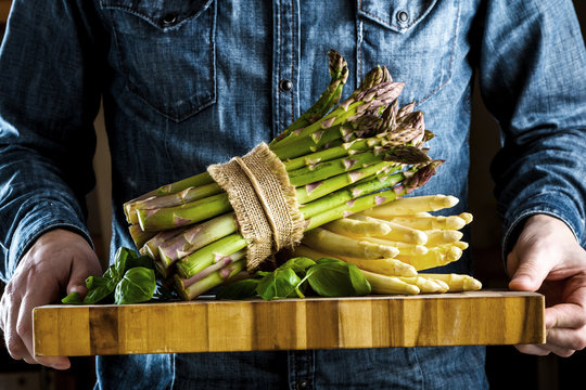 Der Mann h&auml;l gebundenem  gr&uuml;nen und wei&szlig;en Spargel