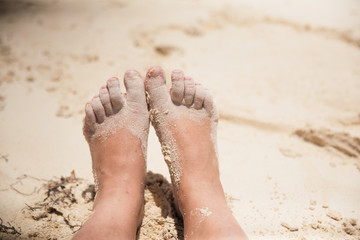 Sandy bare feet and Toes in the beach sand during the summer