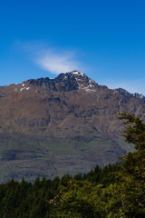 peaceful landscape during sunny day with calm sky above mountain range, perfect hiking area