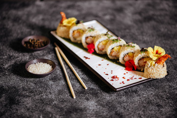 Various kinds of tasty sushi served on black stone