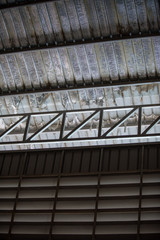An interior space of a factory shop showing a scaffolding metal roof sheet with a framework of...