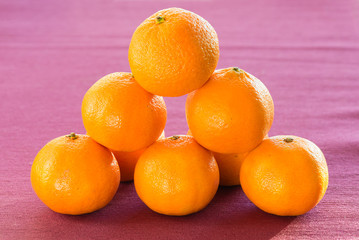 Fresh mandarins on purple background