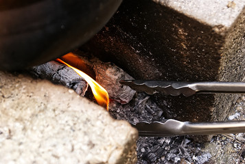metal tongs stuck in coal, ceniñas and firewood, takes close-up