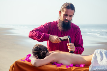 male master makes Thai massage Tok-sen spa therapy physiology by the sea ocean beach.Beautiful...