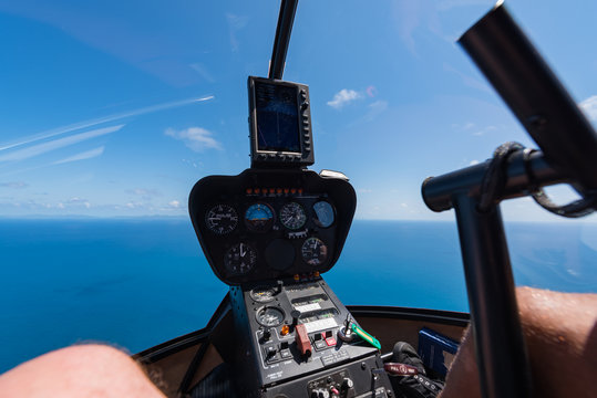 Cockpit eines Helikopters beim Flug über das Meer