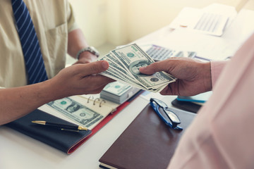 Business and finance concept, Hand of a businessman giving money to his partner.