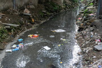 Dirty polluted waste water in big city with garbages. Environment pollution. Urban environment...