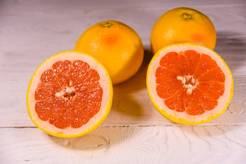 Ripe juicy grapefruit on a white wooden table