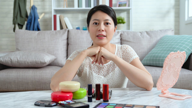 famous vlogger start recording makeup tutorial video talking for blog. young asian fashion girl teaching fans followers how to do make up correctly in live streaming home. cosmetics products on table