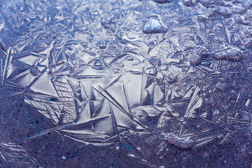 Cloud and sky reflections in an ice pattern on the ground