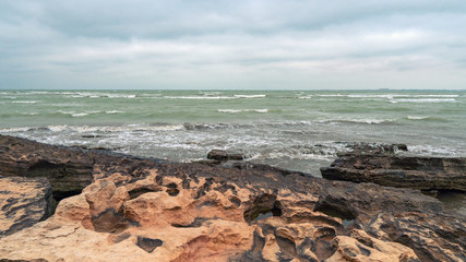 Rocky sea coast in cloudy weather