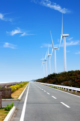風力発電の風車とまっすぐな道