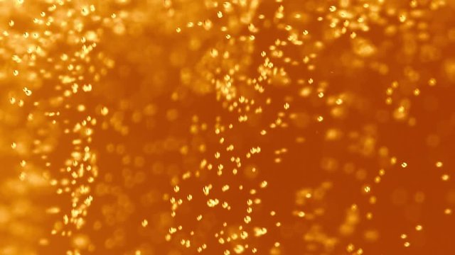 Macro Shot Of Fine Bubbles Rising In A Glass With Orange Liquid