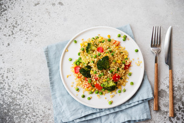 Lenten dish. Bulgur with vegetables in a plate. Pilaf from bulgur, broccoli, green peas, bell peppers and corn.