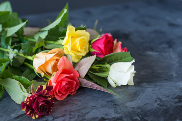 bouquet of colourful roses on black  grey background 