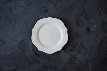 white plate on black wooden background 