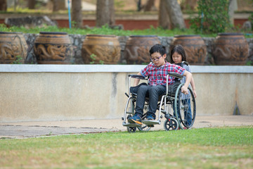 children sitting on wheelchairs