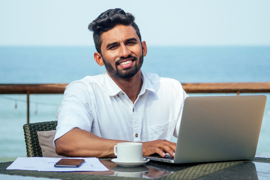 Indian Businessman Working On Tablet Computer Copyspace On Tropical Beach Cafe.freelancer Man In A White Shirt Collar Surfing Online Sale Success And Freedom