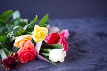 bouquet of colourful roses on black  grey background 