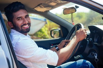 travel vacation happy indian man in white shirt collar buying new car and showing the key, sitting...