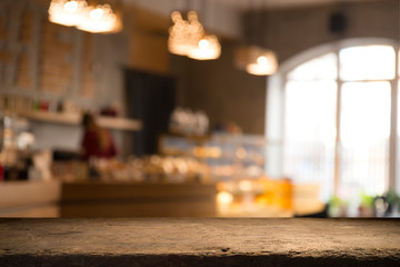 image of wooden table in front of abstract blurred background of resturant lights