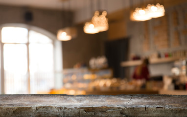 image of wooden table in front of abstract blurred background of resturant lights