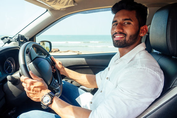 travel vacation happy indian man in white shirt collar buying new car and showing the key, sitting...