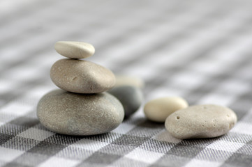 Fototapeta na wymiar Harmony and balance, cairns, simple poise stones on white gray checkered background, rock zen sculpture, white pebbles