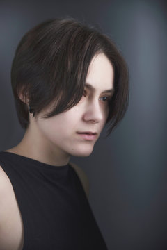 Portrait of an impulsive beautiful young girl with short hair in a black t-shirt and top