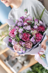 beautiful fresh cut bouquet of mixed flowers in woman hand. the work of the florist at a flower shop. Spring mood