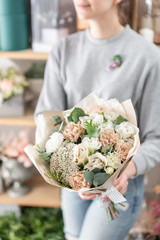 beautiful fresh cut bouquet of mixed flowers in woman hand. the work of the florist at a flower shop. Spring mood