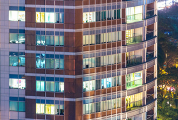 Apartment windows in the night time.  Big city living in highrise urban environment.  Real estate concept.