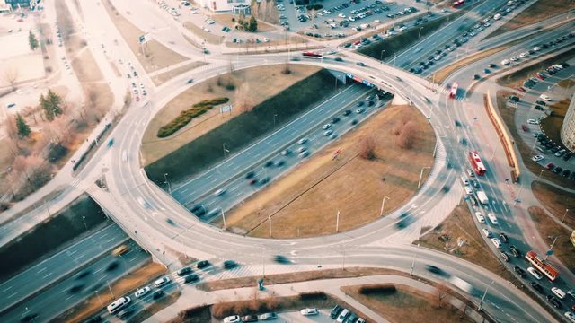 Aerial hyperlapse of city traffic on 4-way intersection roundabout