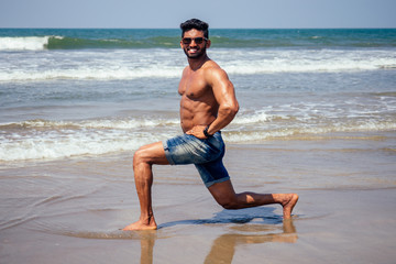 Fototapeta na wymiar portrait of happy young african man on the beach.Handsome and confident Masculine hard fitness model male body bodybuilder with six pack.India trainer with perfect abs, shoulders,biceps, triceps,chest