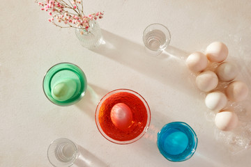 Easter eggs dyeing in glass with colors