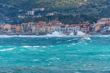 Fototapeta premium Stormy and Windy Mediterranean Sea with a Village in the Distance