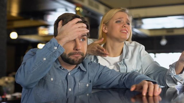 Upset couple sport fans watching game together, bad match result, disappointment